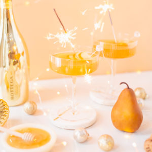 Gilded Vanilla Pear Sparkler | A glitzy, French 75 inspired New Years Eve cocktail featuring 24 karat gold infused gin, Brut Prosecco, Italian vanilla liqueur, lemon juice and Honeyed Vanilla Pear Syrup | Best NYE 2020 cocktails | How to Make sparkling NYE cocktails at home | Champagne cocktail recipe | Champagne Christmas drinks | New Years Eve Sparklers | Modern Refined Sugar Free French 75 | NYE Cocktail Party Recipes | Calgary Creative Lifestyle & Cocktail Blogger // JustineCelina.com