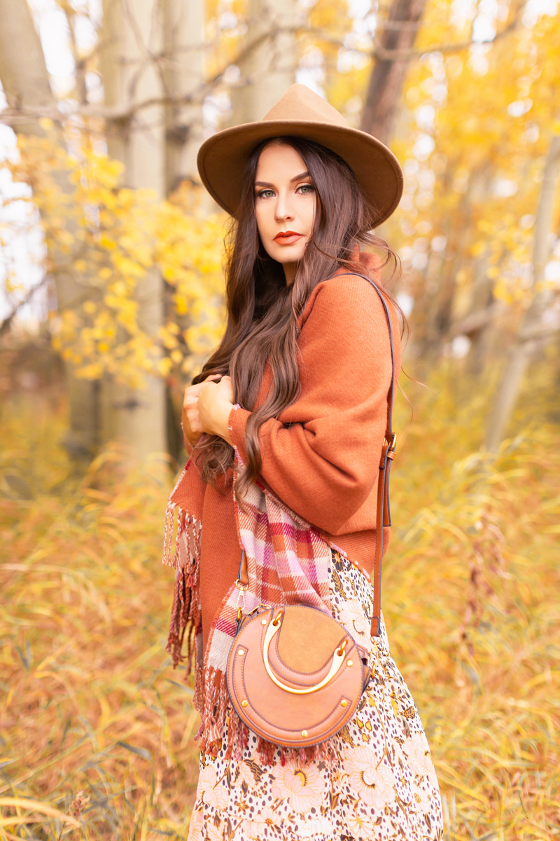 Fall 2020 Lookbook | A Lesson in Layering | Brunette woman wearing a fall floral midi dress, a burnt orange shawl, a brown fedora and a round cognac crossbody bag amongst fall leaves | Boho Fall 2020 Outfit Ideas | Top Fall / Winter 2020 Trends | Bohemian Fall / Winter outfit Ideas | Cottagecore Fall / Winter Outfit Ideas | How to Style Midi Dresses for Fall and Winter | Creative Layering Ideas | How to Mix Prints | Calgary Alberta Fashion Blogger // JustineCelina.com