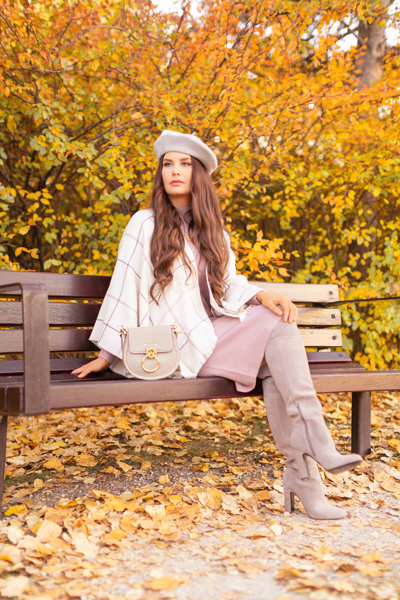 Fall 2020 Lookbook | Ruana Revival | Brunette woman sitting on a park bench surrounded by fall leaves, wearing a cream ruana poncho, cotton blush sweater dress, grey beret, grey Chloe Tess bag, and grey knee high suede boots | Boho Fall 2020 Outfit Ideas | Fall in Calgary | How to Style a Poncho | Comfortable Fall / Winter Outfit Ideas | Timeless Fall Outfit Ideas | fallwinter 2020 2021 fashion trends | fall 2020 womens fashion trends |  Calgary Alberta Fashion Blogger // JustineCelina.com
