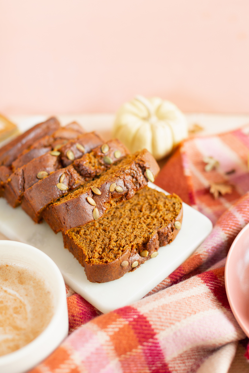 Gluten Free Mapled Pumpkin Chai Bread | Sliced Pumpkin Bread on a Marble Serving Board, served on 2 pink plates with gold forks and a chai latte | Chai Spice Bread styled with spices and white mini pumpkins arranged on blush pink barn board backdrop | Easy Pumpkin Bread | Moist Pumpkin Bread | The Best Gluten Free Fall Baking Recipes | No Sugar Pumpkin Bread | Maple Syrup Pumpkin Bread | Pumpkin Bread Cake | Healthy Pumpkin Bread | Calgary Plant Based Food Blogger // JustineCelina.com