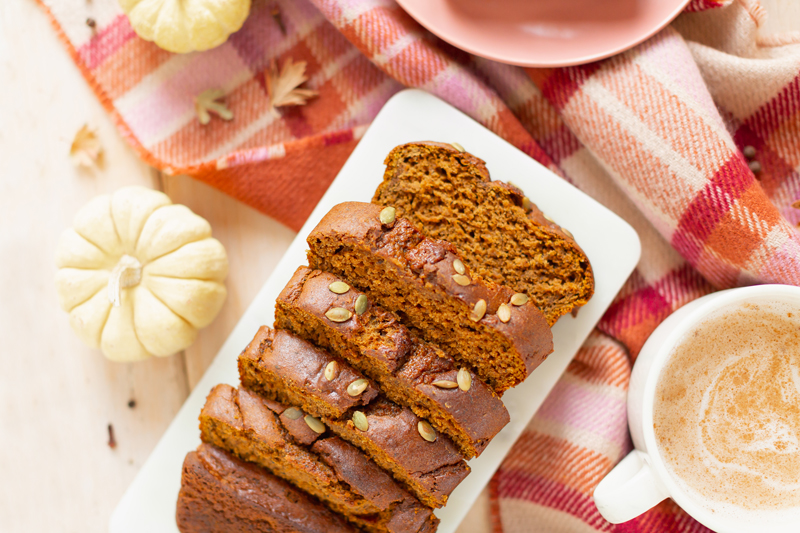 Gluten Free Mapled Pumpkin Chai Bread | Sliced Pumpkin Bread on a Marble Serving Board, served on 2 pink plates with gold forks and a chai latte | Chai Spice Bread styled with spices and white mini pumpkins arranged on blush pink barn board backdrop | Easy Pumpkin Bread | Moist Pumpkin Bread | The Best Gluten Free Fall Baking Recipes | No Sugar Pumpkin Bread | Maple Syrup Pumpkin Bread | Pumpkin Bread Cake | Healthy Pumpkin Bread | Calgary Plant Based Food Blogger // JustineCelina.com