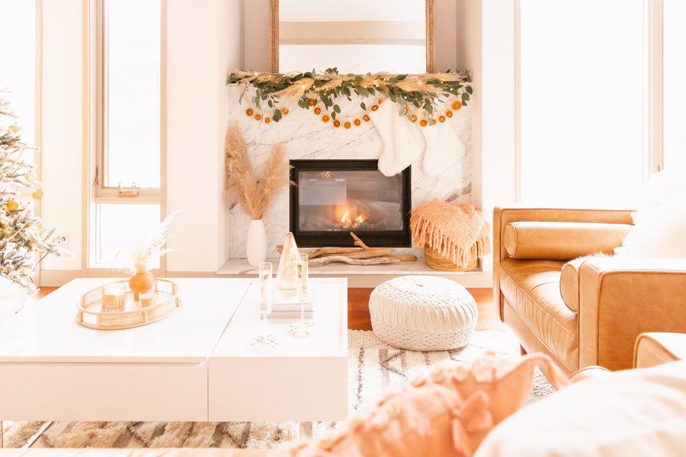 Mid Century Meets Boho Holiday Decor | Bright airy Mid Century Modern Living Room with a boho eucalyptus garland with pampas grass, fresh cedar, bleached Italian ruscus and a beaded dried orange garland | Boho Christmas Decorating Ideas for Apartments | Boho Holiday Fireplace Decor | DIY Orange Slice Garland | Bohemian Holiday Home Tour 2021 | Boho Chic Christmas Decor | Glam neutral holiday decor | Warm toned Holiday decor | Fun Holiday Decor | Dried Fruit Holiday Decor // JustineCelina.com