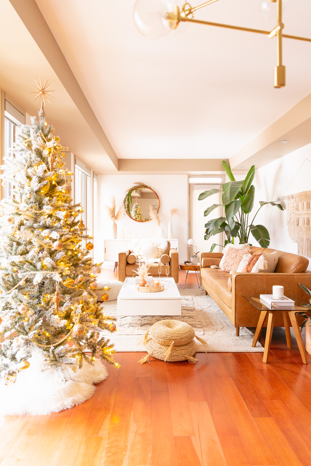 Mid Century Meets Boho Holiday Decor 2021 | Bright & airy Mid Century Modern Living Room with a Flocked Christmas Tree and Sputnik Metallic Tree Topper | Eucalyptus garland with pampas grass and dried orange slices | Boho Christmas Decorating Ideas for Apartments | Flocked Christmas Tree with Wood Garland and Boho Ornaments | Holiday Home Tour | Boho Chic Christmas Decor | Neutral holiday decor | Bird of Paradise Plant Holiday Decor | Boho Christmas Tree // JustineCelina.com