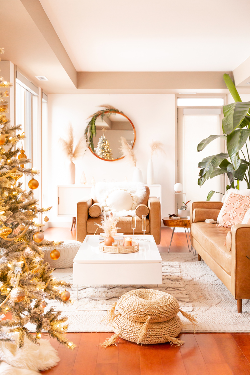 Mid Century Meets Boho Holiday Decor | Bright and airy Mid Century Modern Living Room with a Flocked Christmas Tree and Caramel Leather Couches | Mid Century Modern Christmas Tree Skirt | Boho Christmas Decorating Ideas for Apartments | Flocked Christmas Tree with Wood Garland, Metallic and Wood Ornaments | Bohemian Holiday Home Tour 2020 | Boho Chic Christmas Decor | Glam neutral holiday decor | Warm Holiday Decor | Pampas Grass Holiday Arrangement | Boho Christmas Tree // JustineCelina.com