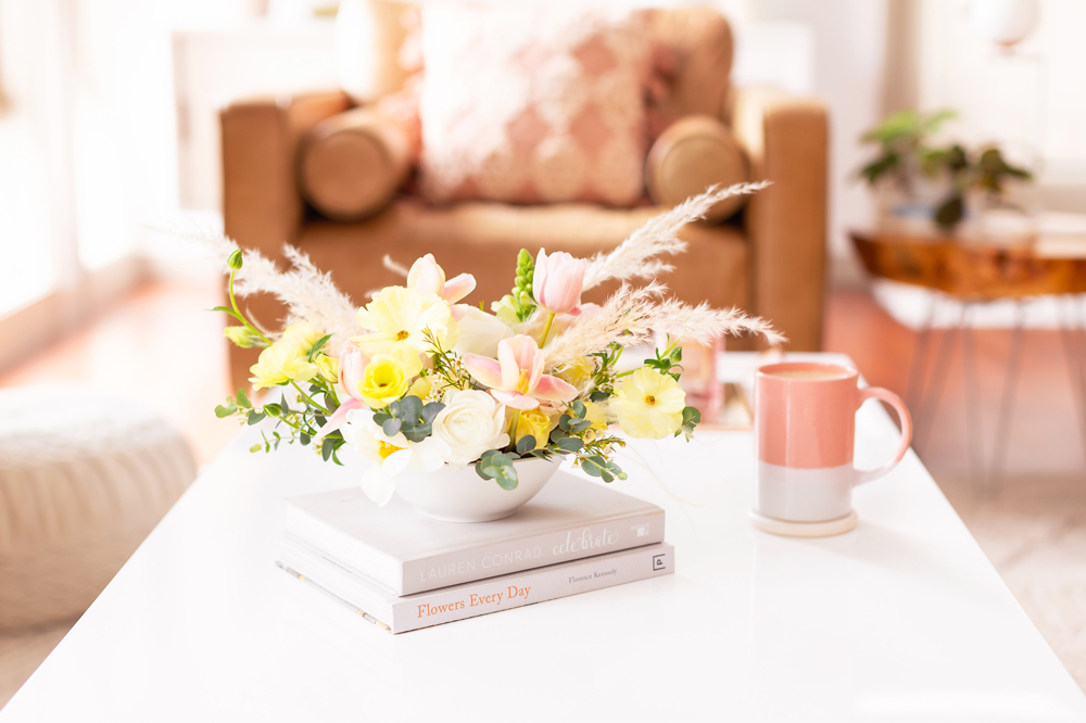 Easter flowers with pampas grass on white coffee table with a pink mug in bright and airy boho living room | Calgary Lifestyle Blogger // JustineCelina.com