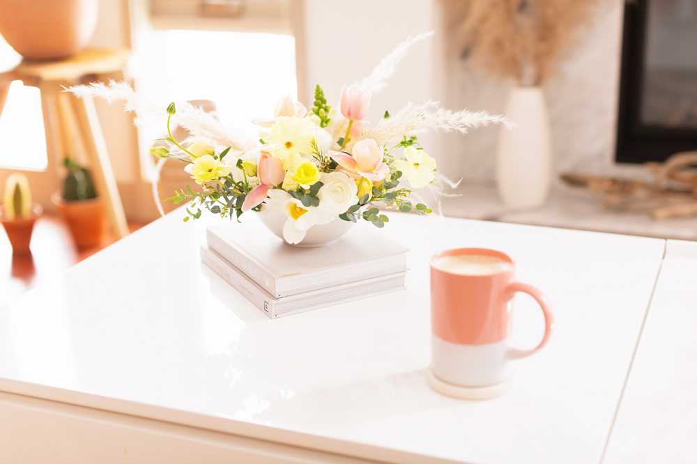Easter flower arrangement with pampas grass on white coffee table with a pink mug in bright and airy boho living room | Calgary Lifestyle Blogger // JustineCelina.com