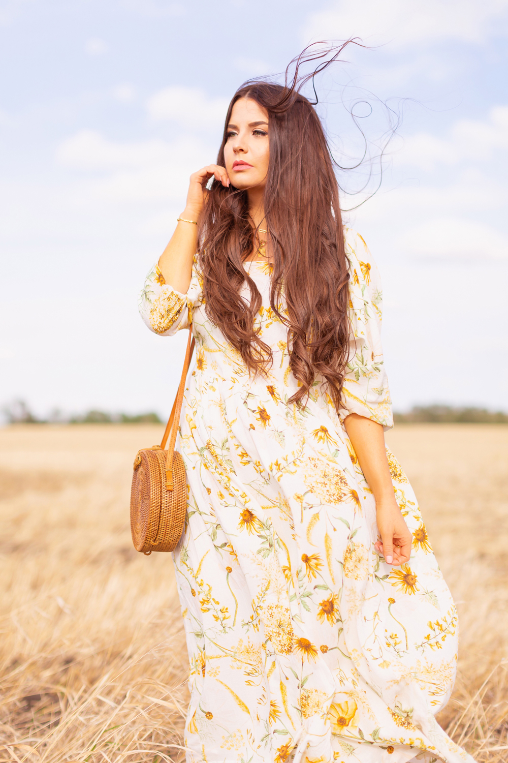 H&M Wildflower Collection Review | Brunette woman wearing a H&M A Meadow of Wildflowers Collection Long Crinkled Dress and a Balinese round rattan bag in a wheat field in the wind | H&M Wildflower Collection Canada | H&M Wildflower Collection Canada | Spring/Summer 2021 Trends | The Best Cotton Dresses 2021 | Boho Spring / Summer Outfit Ideas | Alberta Wildflower Field | Cottage Core Fashion | Cottagecore Outfits | Calgary Creative Lifestyle & Fashion Blogger // JustineCelina.com