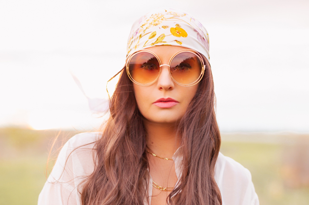 H&M Wildflower Collection Review | Brunette woman wearing a H&M A Meadow of Wildflowers Collection Patterned Satin Scarf on her head with flowy white cotton dress, airy button down shirt and oversized sunglasses in a field at sunset | H&M Wildflower Collection Canada | H&M Wildflower Collection Canada | Spring/Summer 2021 Trends | The Best Cotton Dresses 2021 | Boho Spring / Summer Outfit Ideas | Calgary Creative Lifestyle & Fashion Blogger // JustineCelina.com