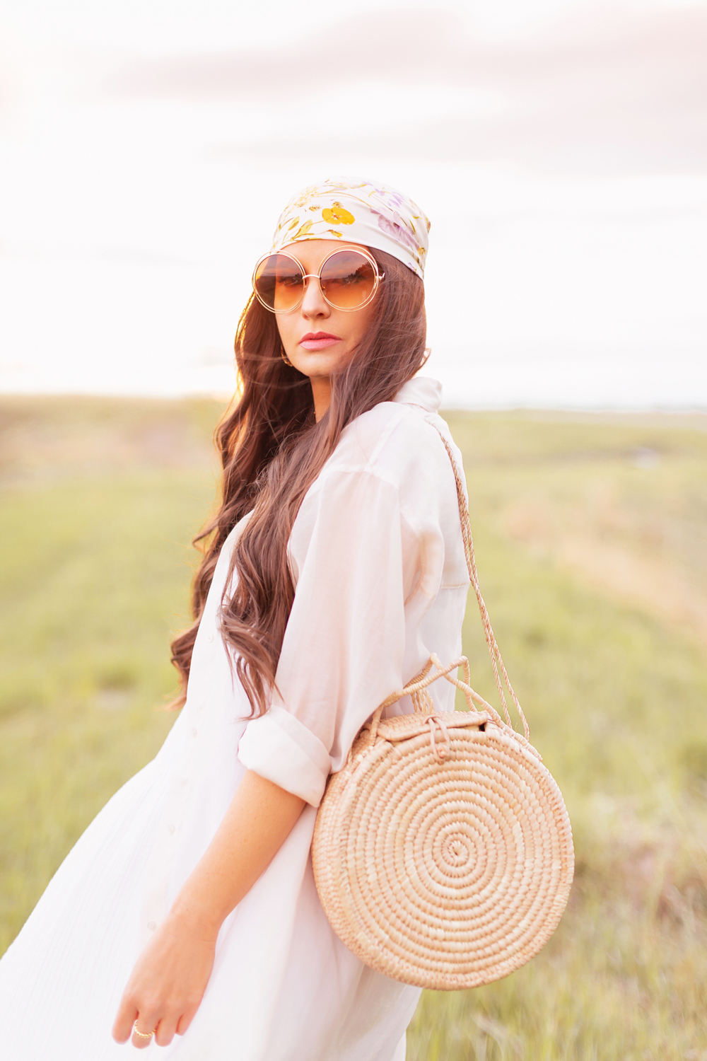 H&M Wildflower Collection Review | Brunette woman wearing a H&M A Meadow of Wildflowers Collection Patterned Satin Scarf on her head with flowy white cotton dress, airy button down shirt, natural material bag and oversized sunglasses in a field at sunset | H&M Wildflower Collection Canada | H&M Wildflower Collection Canada | Spring/Summer 2021 Trends | The Best Cotton Dresses 2021 | Boho Spring / Summer Outfit Ideas | Calgary Creative Lifestyle & Fashion Blogger // JustineCelina.com