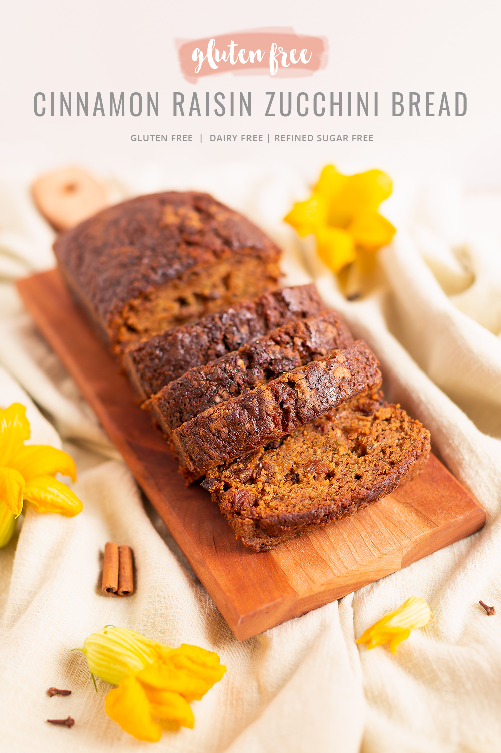 Cinnamon Raisin Zucchini Bread {Dairy Free, Gluten Free, Refined Sugar Free} | Freshly baked, sliced Zucchini Bread on a wooden serving board surrounded by squash blossoms, cinnamon sticks and cloves | Moist Zucchini Bread Recipe | Easy Cinnamon Raisin Loaf | Best Baking Recipes for Overgrown Garden Zucchini | Zucchini Bread Cake | Healthy Cinnamon Zucchini Bread | What to do with large zucchini | Zucchini Bread with Crispy Top | Calgary Plant Based Food Blogger // JustineCelina.com
