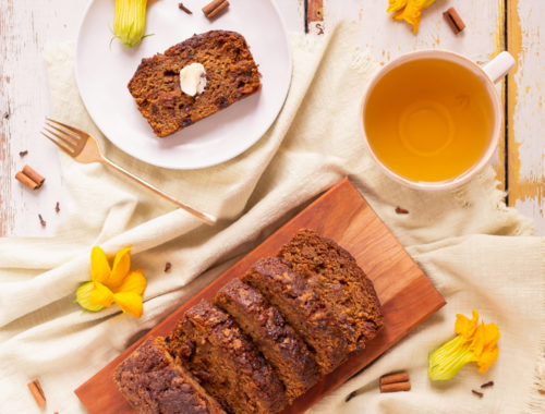 Cinnamon Raisin Zucchini Bread {Dairy Free, Gluten Free, Refined Sugar Free} | Freshly baked, sliced Zucchini Bread on a wooden serving board surrounded by squash blossoms, cinnamon sticks and cloves | Moist Zucchini Bread Recipe | Easy Cinnamon Raisin Loaf | Best Baking Recipes for Overgrown Garden Zucchini | Zucchini Bread Cake | Healthy Cinnamon Zucchini Bread | What to do with large zucchini | Zucchini Bread with Crispy Top | Calgary Plant Based Food Blogger // JustineCelina.com