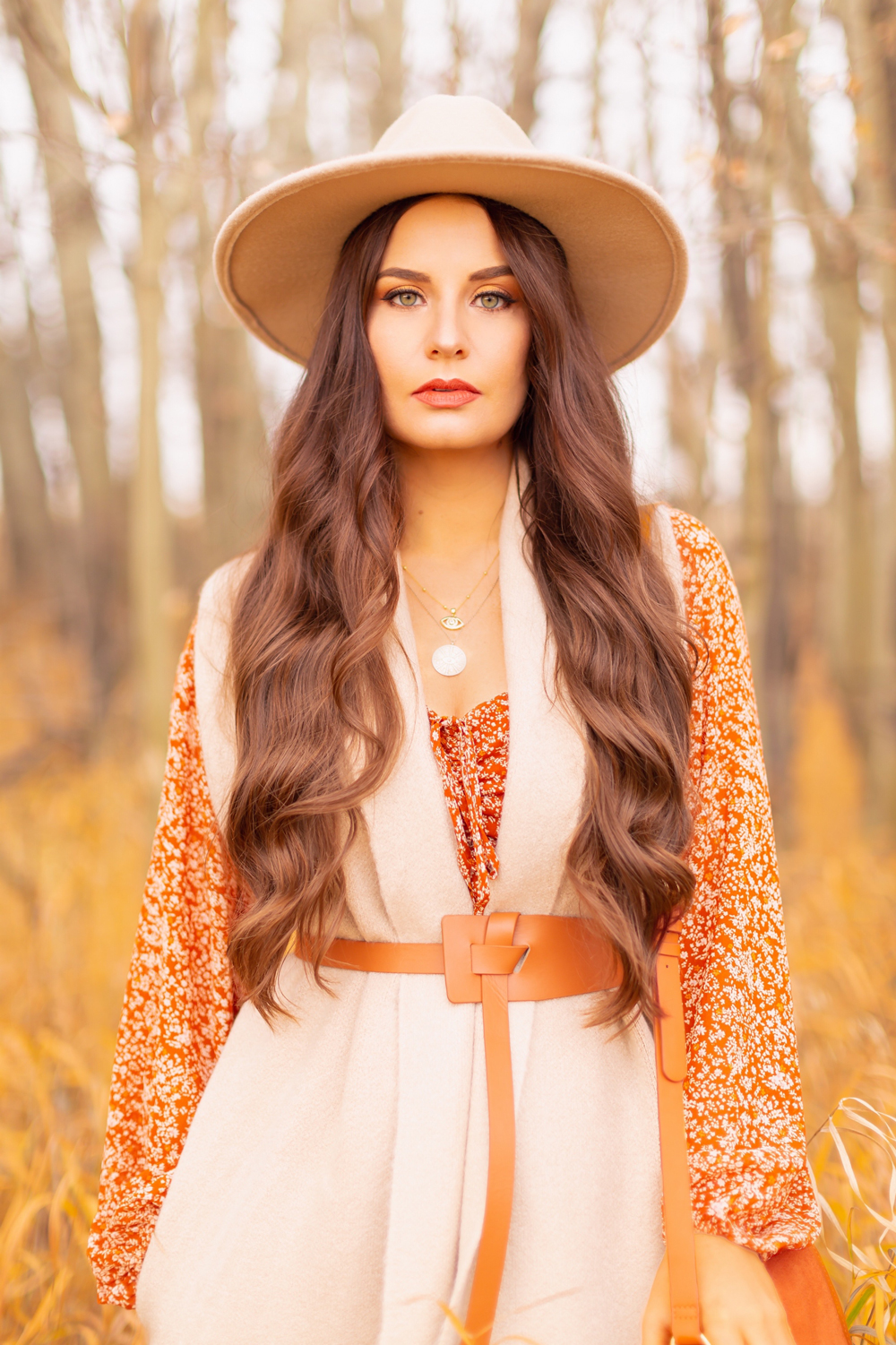 6 Luxe Bohemian Fall Outfits | Rancher Revival | Woman with waxy waist length brown hair wearing an orange floral mini dress, beige Pink Martini Stockport Vest, wide cognac waist belt with tie detail and a beige rancher hat | Boho Fall 2022 Outfit Ideas | Classic Fall Outfit Formulas | Feminine Bohemian Style | Bohemian Outfit Ideas | How to Style a Rancher Hat | Calgary Alberta Fashion Blogger // JustineCelina.com
